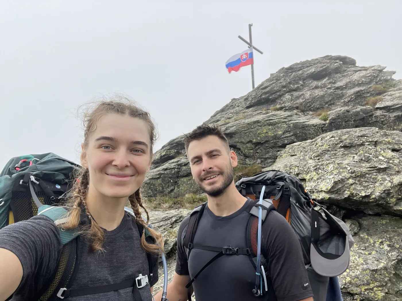 Soňa a Filip na turistike pri vrchole so slovenskou vlajkou